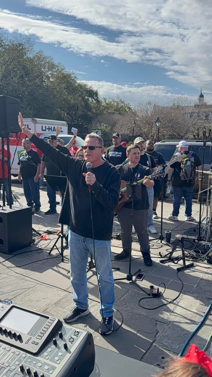 Man preaching with band