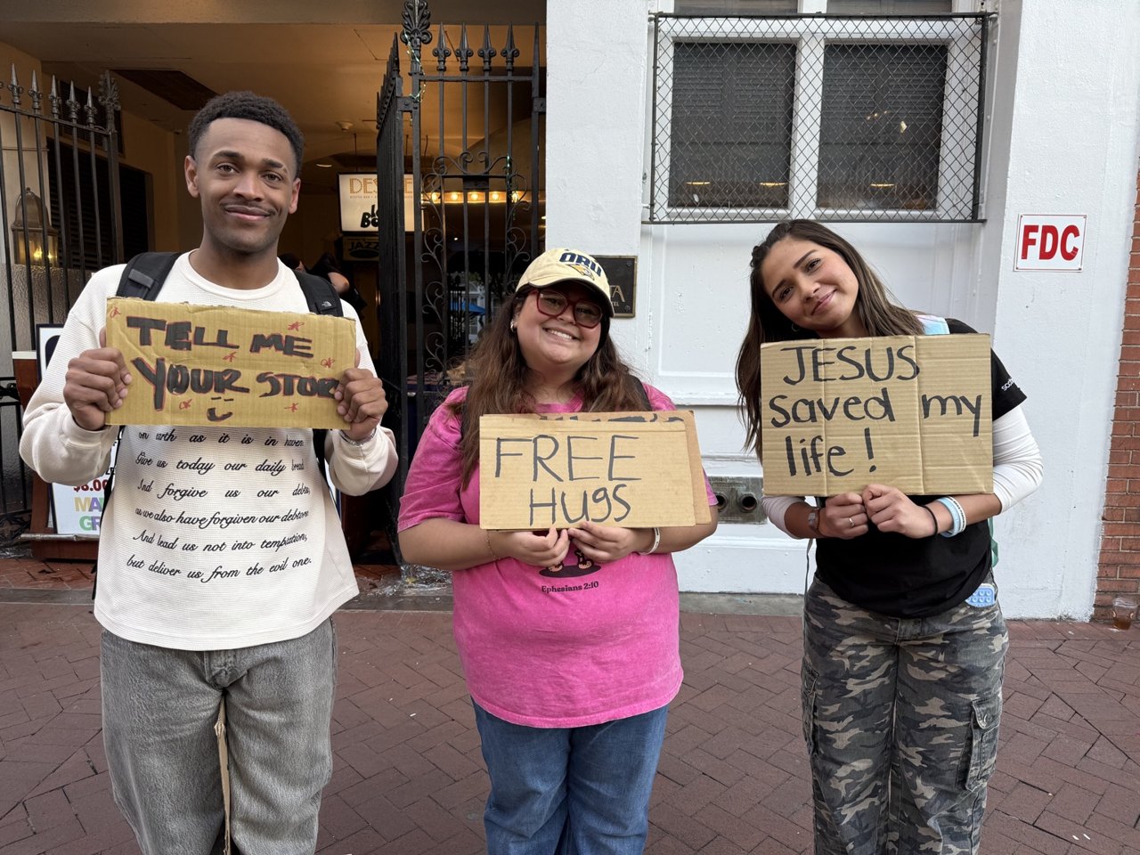 Three people holding signs